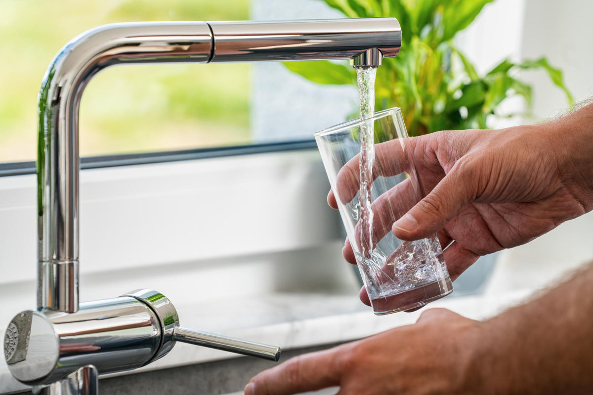 Clean water from the tap poured into the glass.